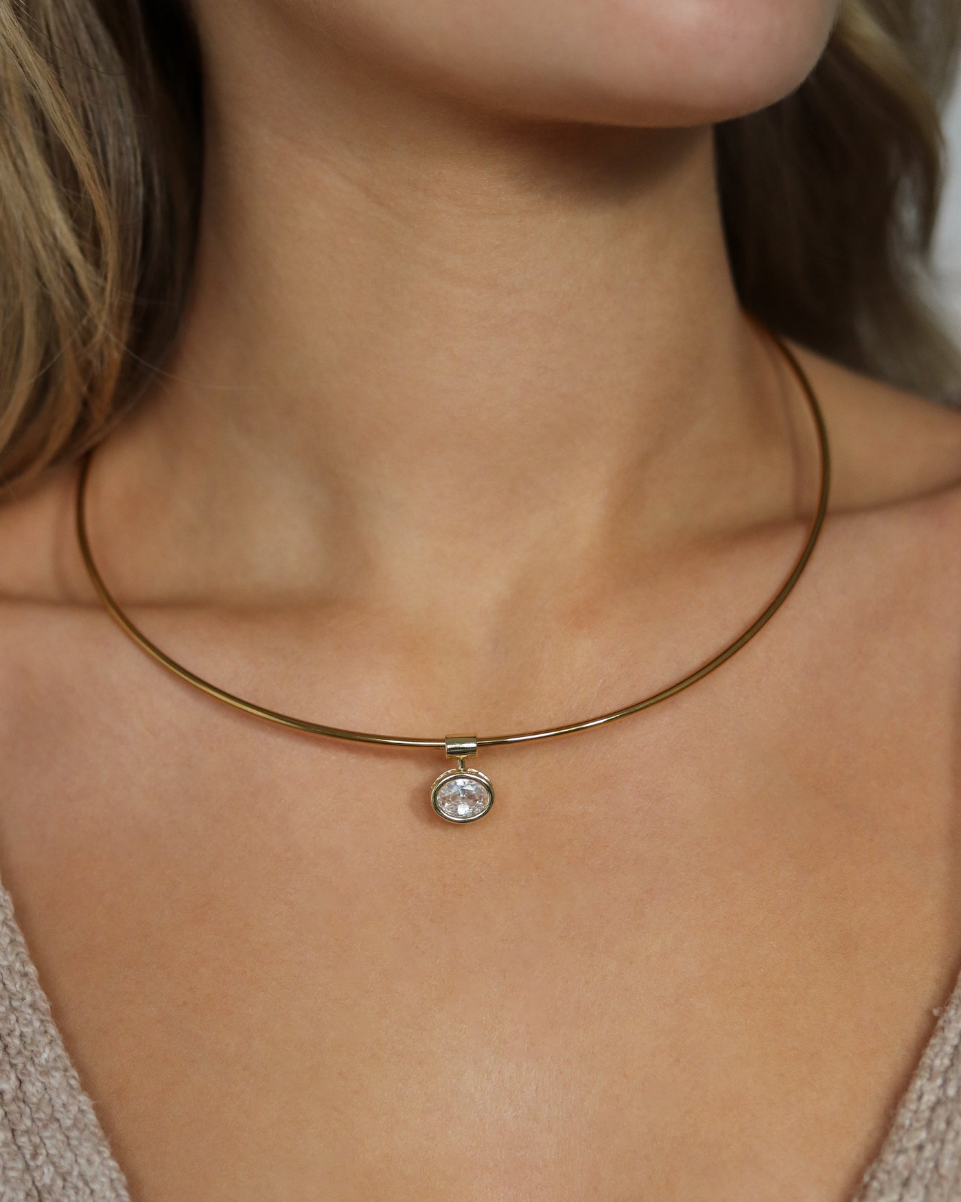 Close-up of a collar necklace with a pendant on a person's neck